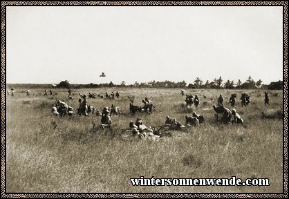 Mit Maschinengewehr und Munition vorgehende deutsche Askaris.