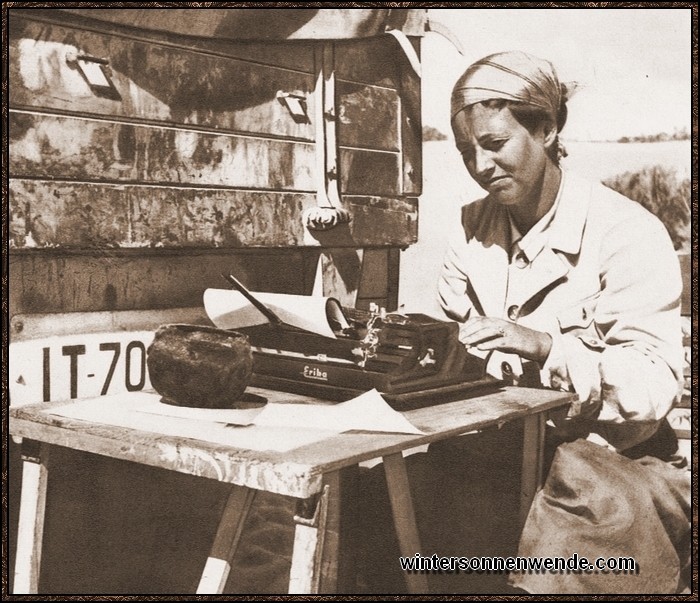 Eine Assistentin der Frobenius-Expedition beim Fahrtenbericht im Schatten des 
Expeditions-Lastwagens.